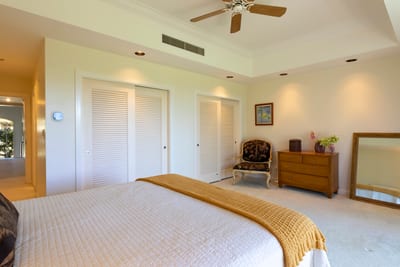 Dream easy in this elegant island bedroom with soft linens, fresh air, and calming green tones
