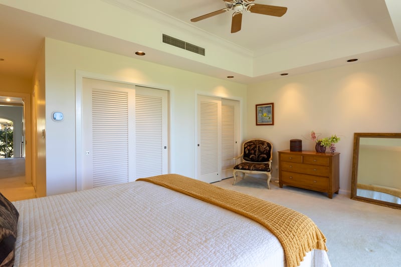 Dream easy in this elegant island bedroom with soft linens, fresh air, and calming green tones