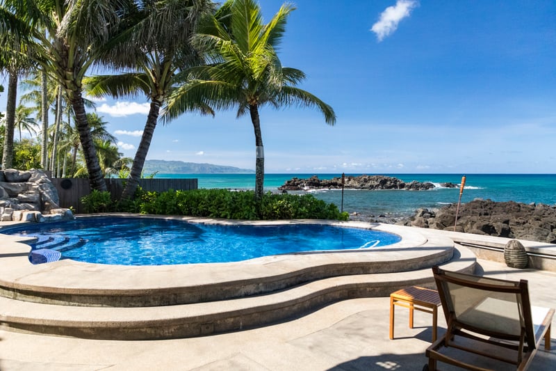 Soothing tones and tropical flair in a sunlit room made for rest, comfort, and relaxation