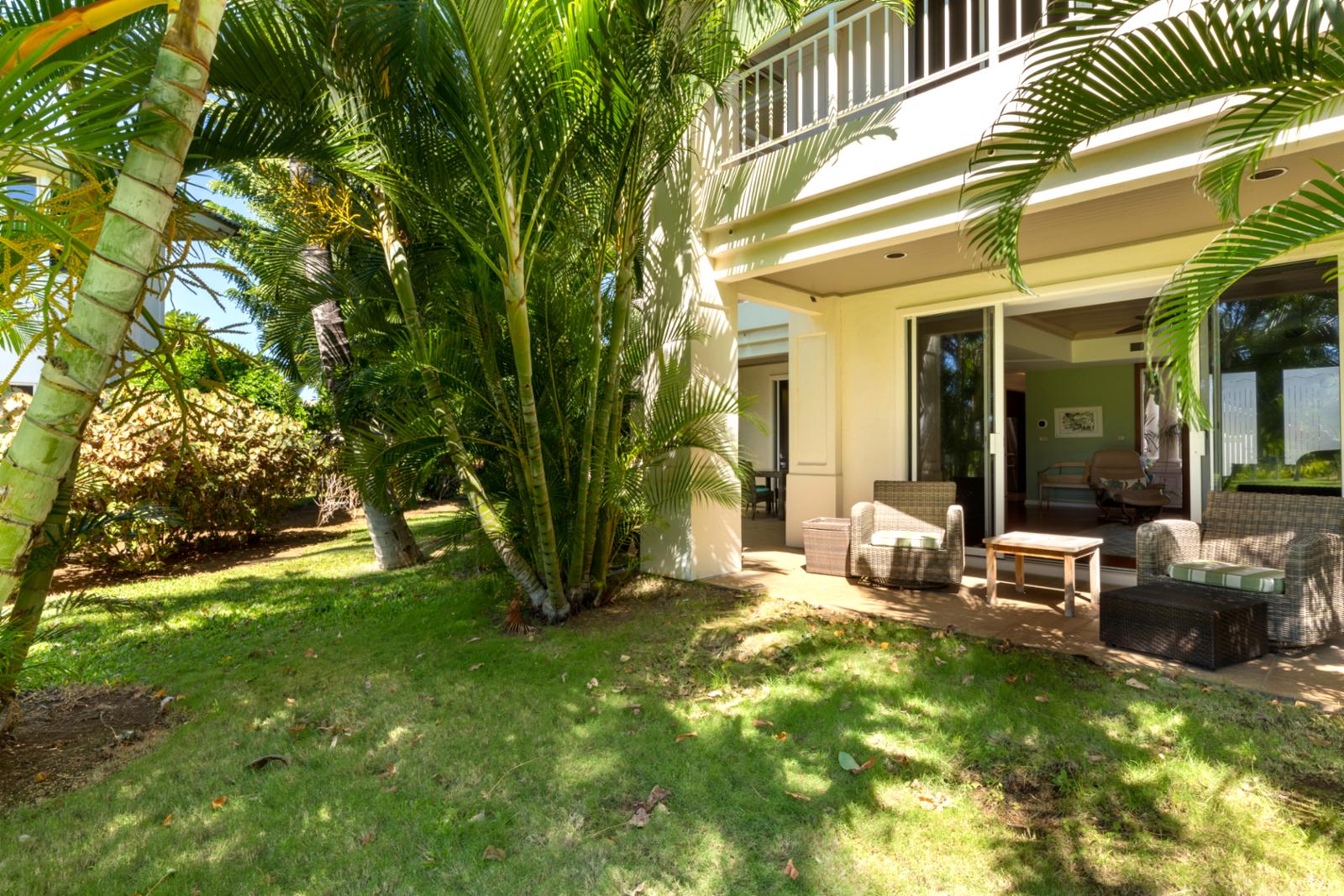 Lush tropical lanai with cozy seating and serene garden escape.