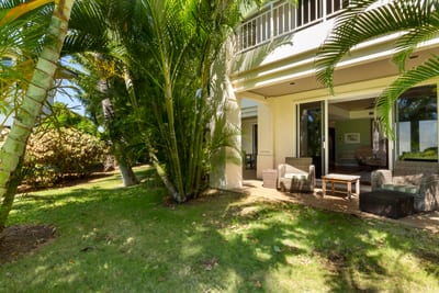 Lush tropical lanai with cozy seating and serene garden escape.