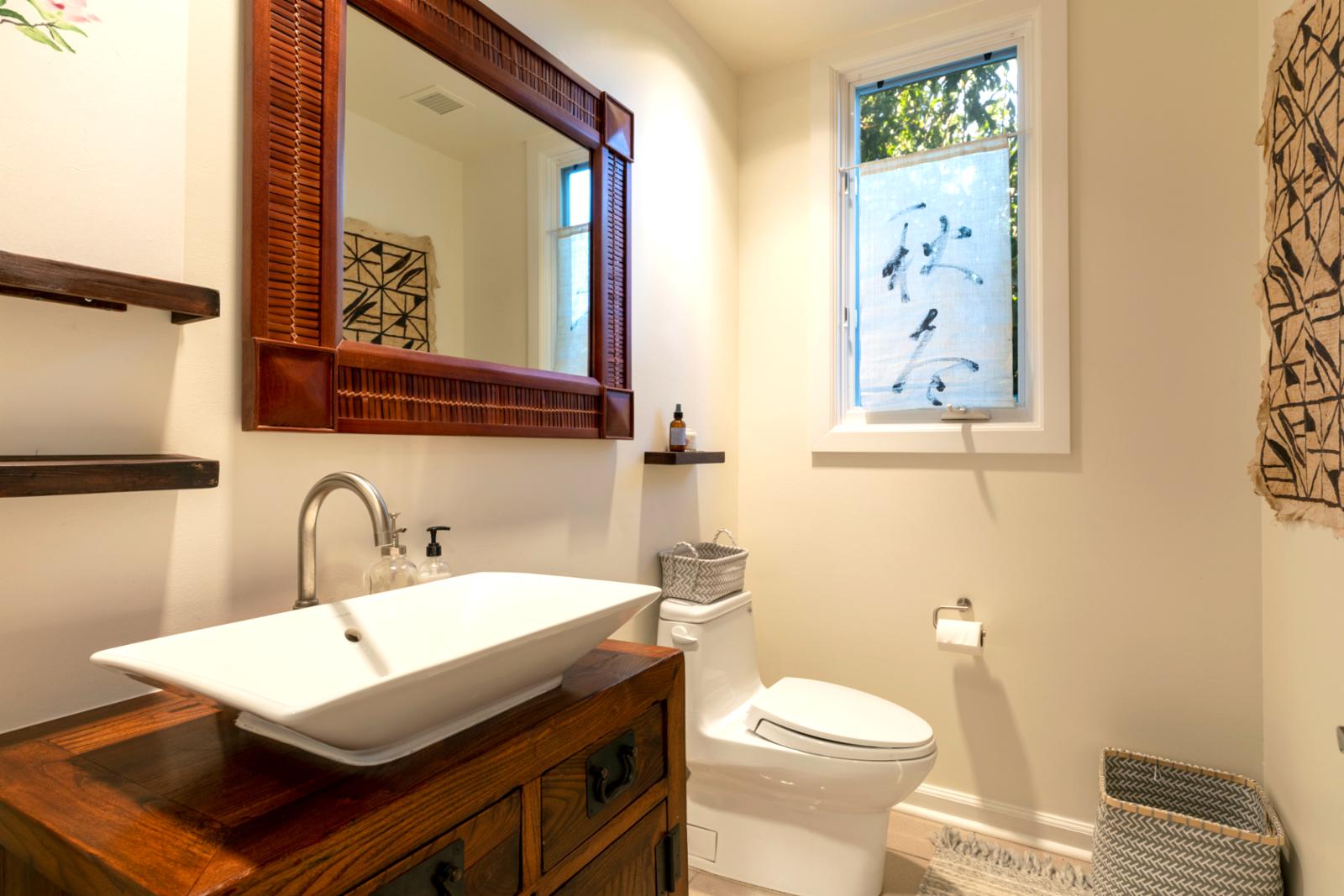 Stylish tropical powder room with vessel sink and artistic accents.