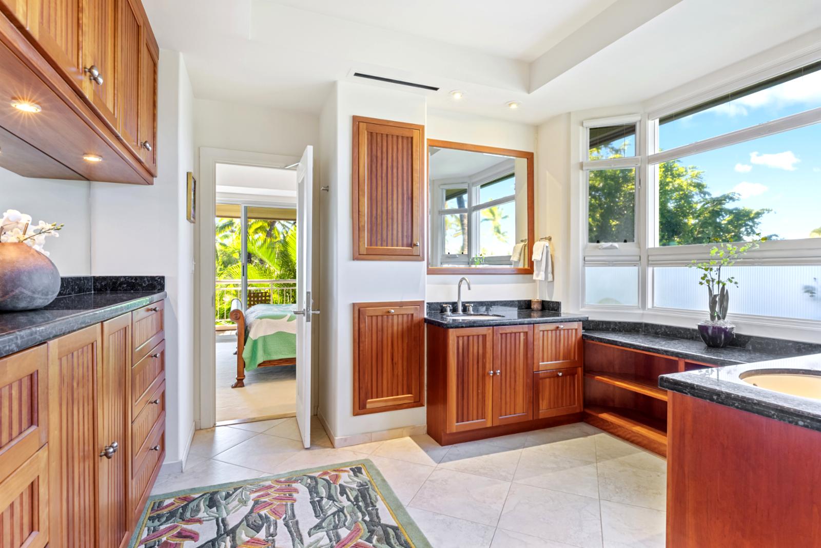 Bright spa-style bathroom with tropical views and custom wood cabinetry.
