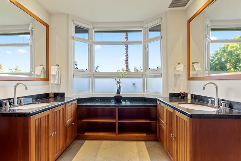 Sunlit spa-style bathroom with rich wood, sleek stone, and serene views
