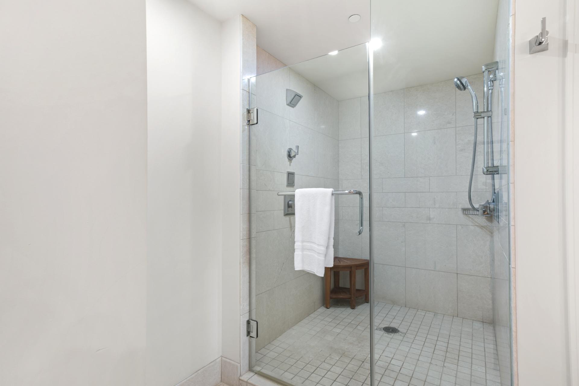 Contemporary walk-in shower with luxury L'Occitane bath amenities.