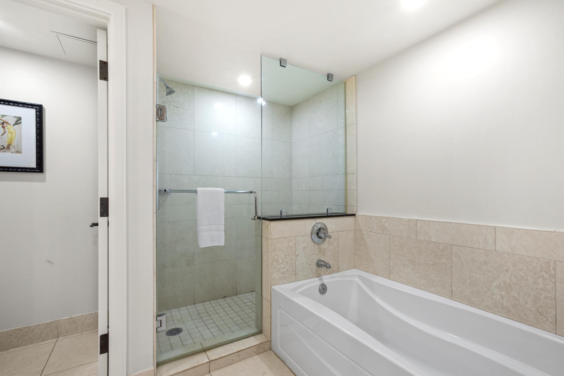 Modern bathroom with glass shower, deep soaking tub, and elegance.