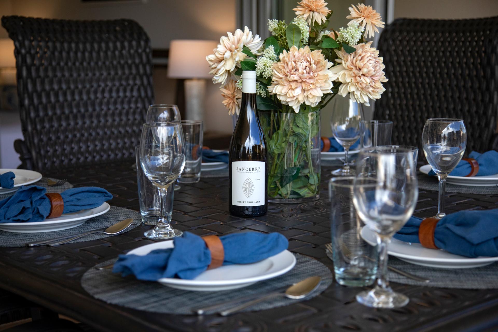 Elegant table setting with wine, florals, and coastal dinner ambiance