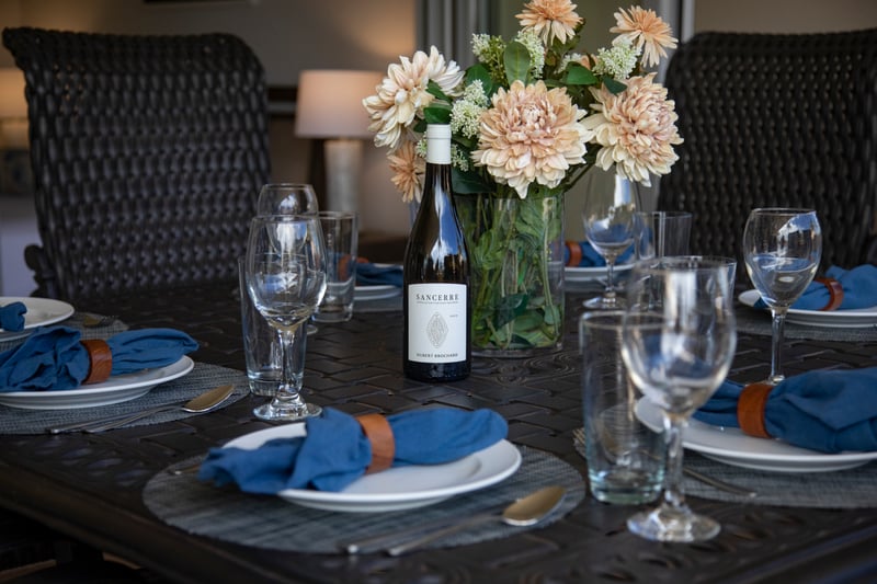 Elegant table setting with wine, florals, and coastal dinner ambiance