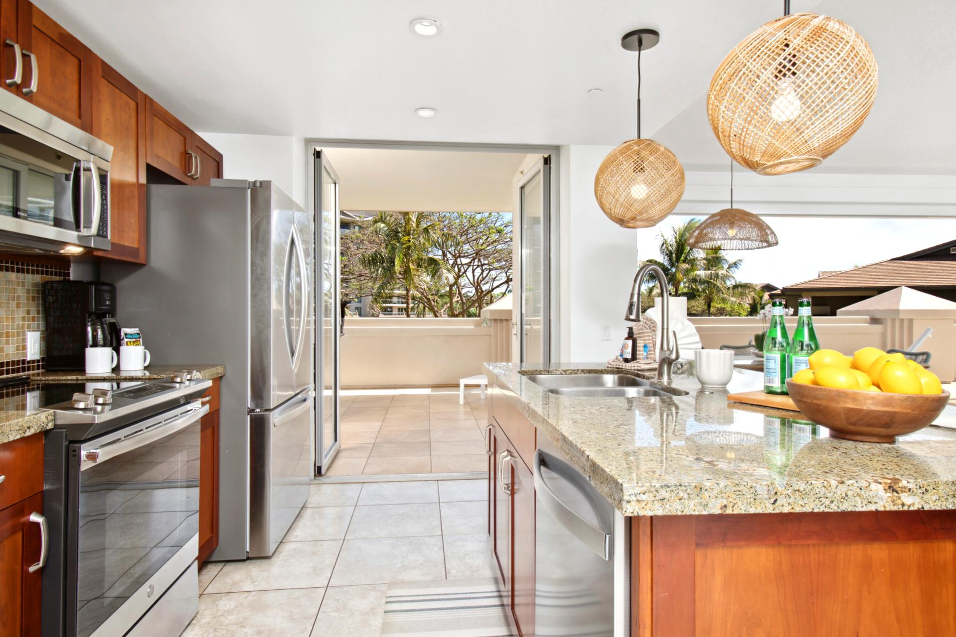 Spacious island kitchen opens to sun-drenched lanai and palm views