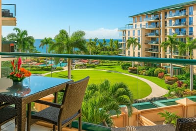 Scenic lanai dining with lush resort landscaping, mountain-lined horizon, and distant ocean sparkle. HKH-423