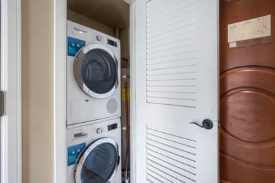 Compact laundry closet with modern stacked Bosch washer and dryer. HKH-520