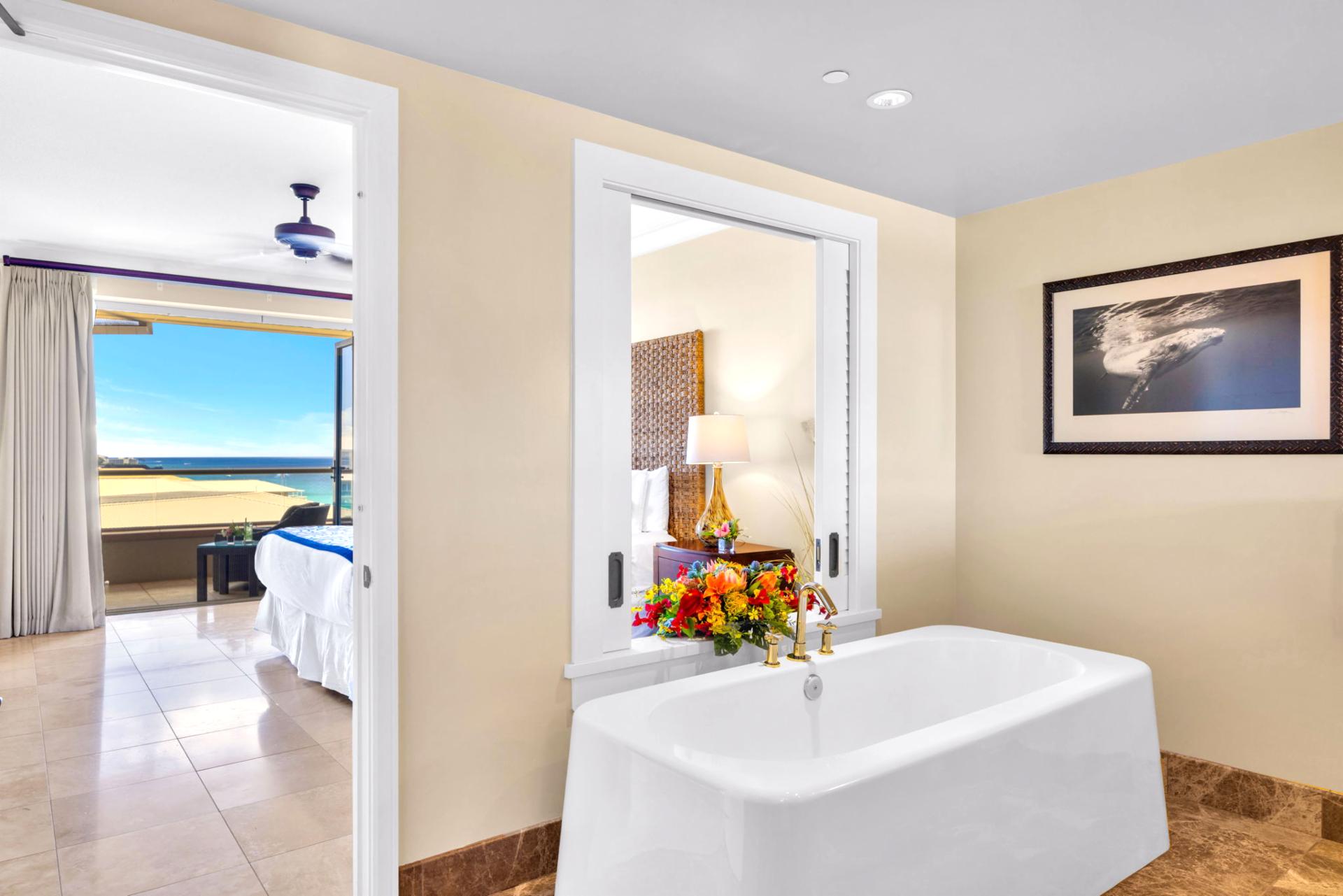 Master bath with a soaking tub, featuring ocean views 