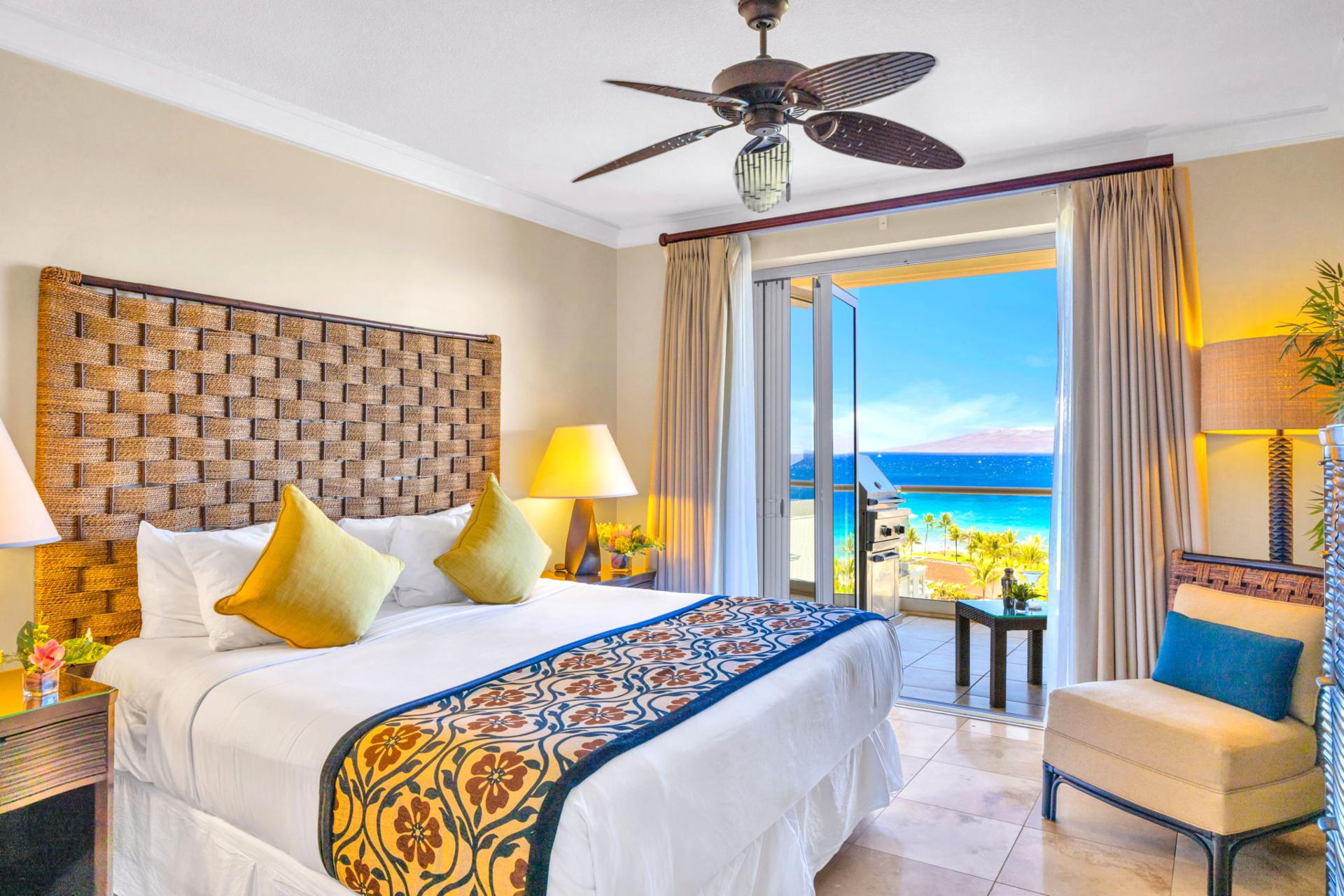 The spacious guest bedroom features tropical accents and ocean views