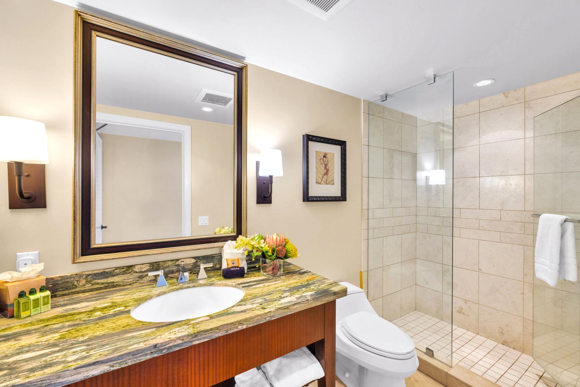 The well lit hall bathroom features a walk in glass shower, convenient for additional guests or rinsing off after the beach