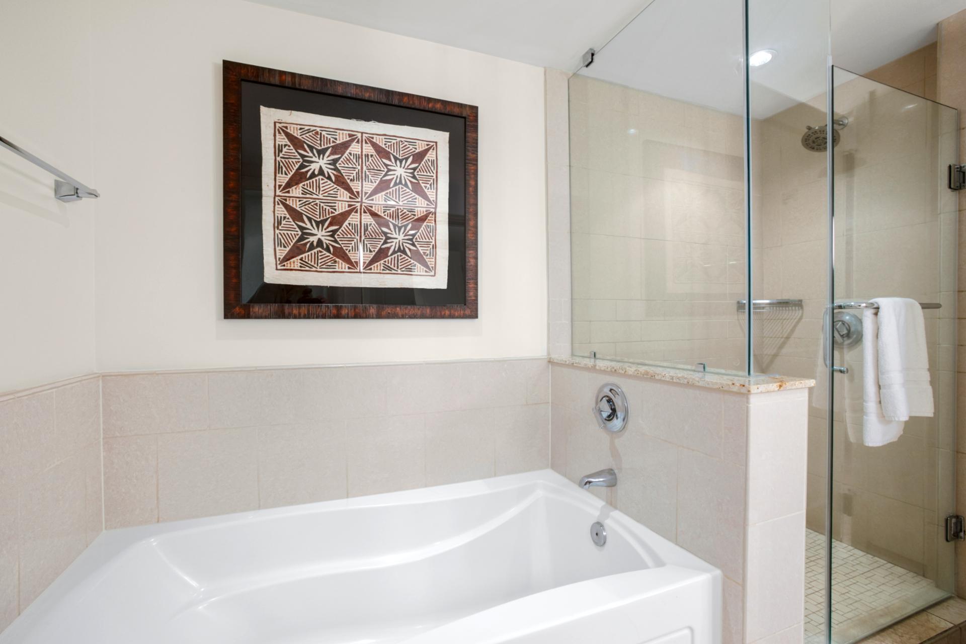 Luxurious soaking tub and glass shower with island-inspired wall art.