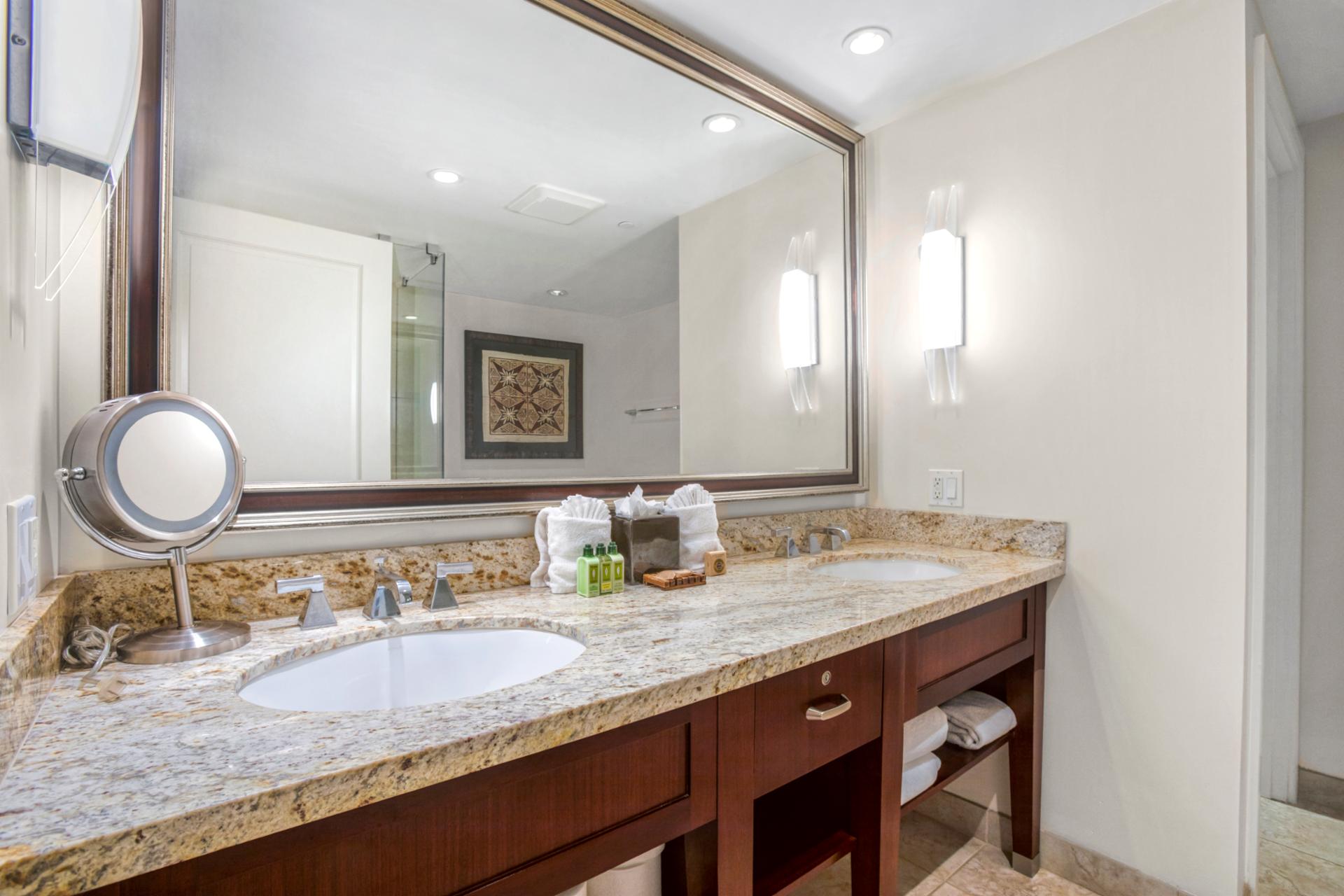 Spacious double vanity bathroom with granite counters and warm lighting elegance.