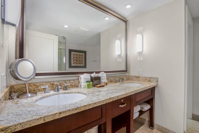 Spacious double vanity bathroom with granite counters and warm lighting elegance. HKK-201