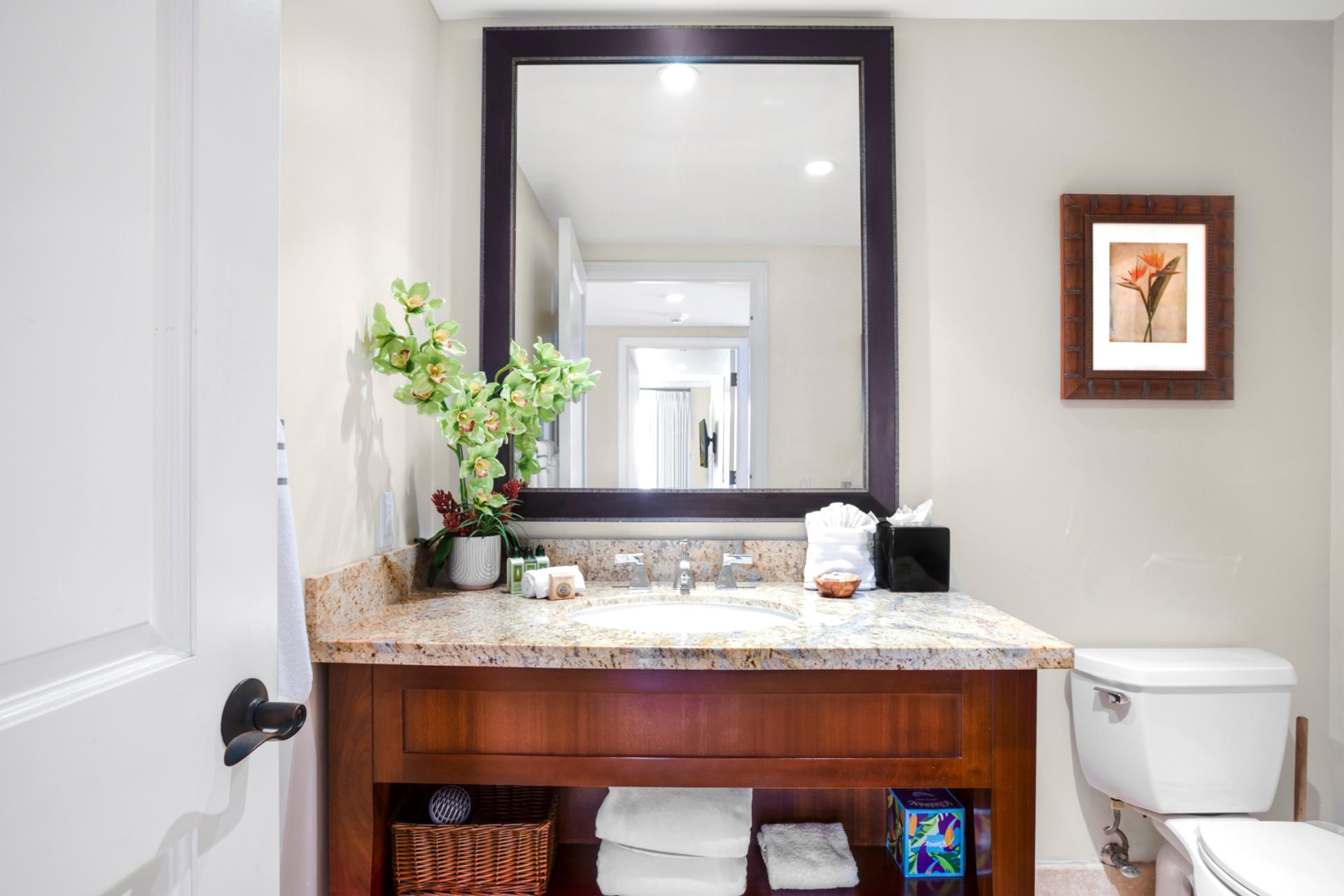 Elegant bathroom vanity with granite countertop and tropical-inspired decorative accents.