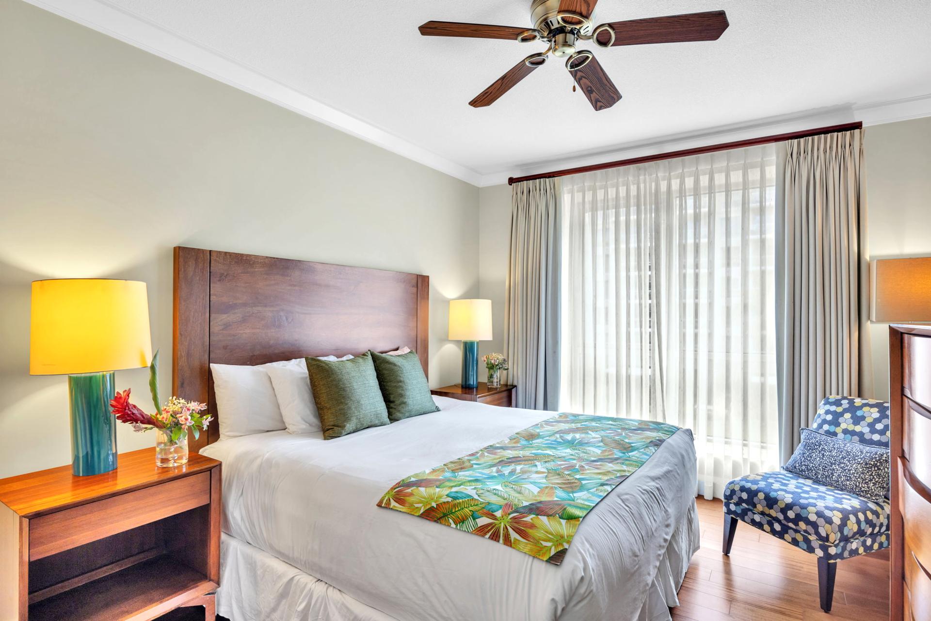 Comfortable and well lit guest bedroom with king bed and private balcony access