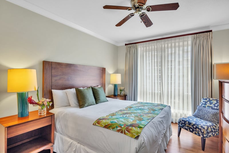 Comfortable and well lit guest bedroom with king bed and private balcony access
