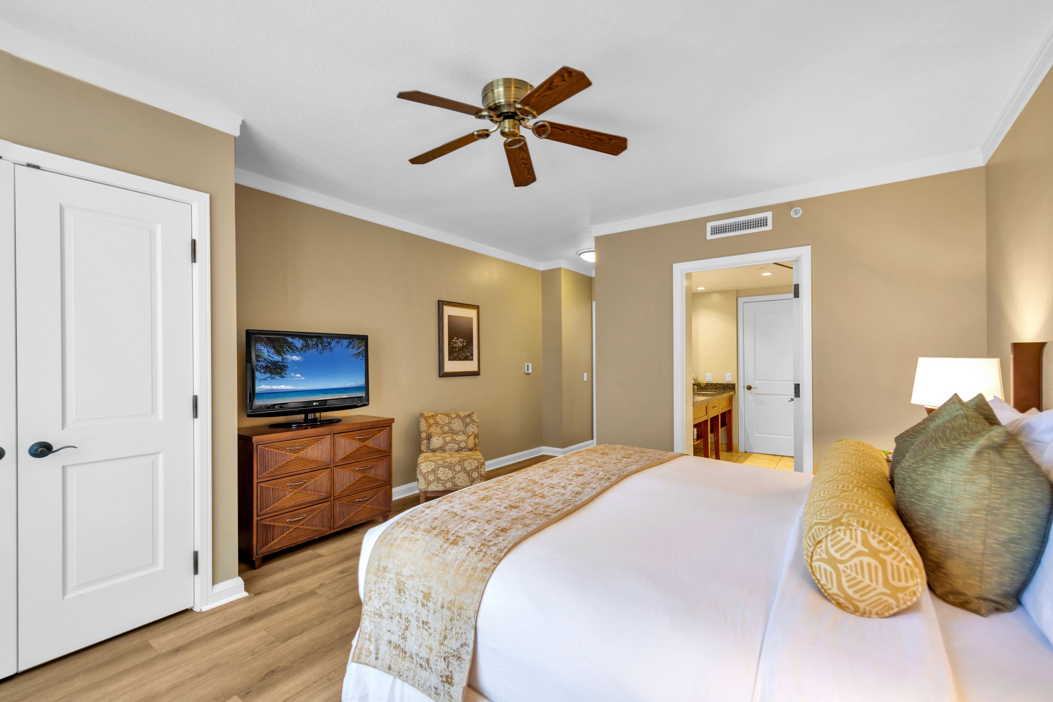 The relaxing guest bedroom features island decor and an ensuite bath