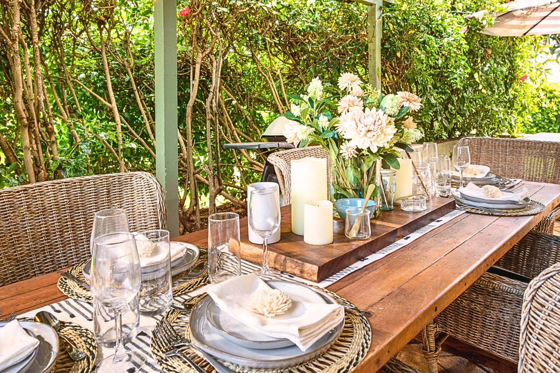 Rattan chairs and rustic wood welcome barefoot meals kissed by blossoms and cloaked in gentle hush.