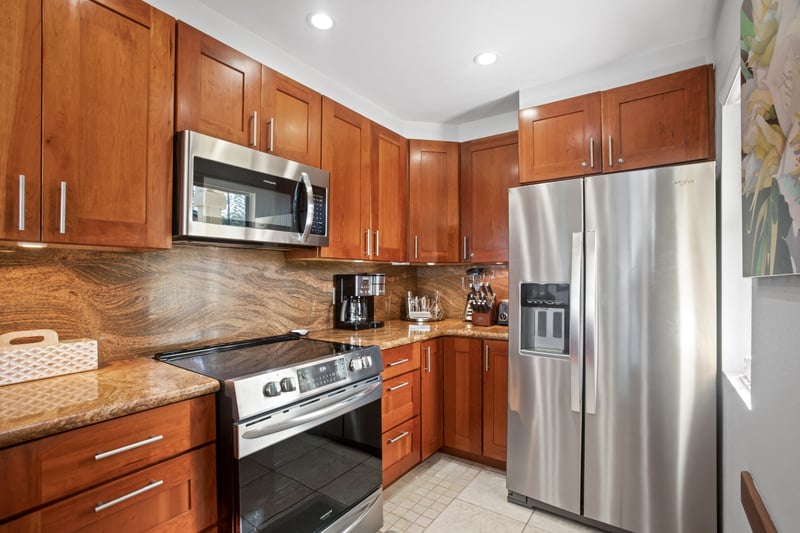 This glossy wood-toned kitchen feels like a warm hug—where coffee brews strong, and breakfasts come with a tropical twist