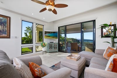 Sunshine pours through glass doors, the sea sparkles in the distance, and the pillows practically beg for a midday nap