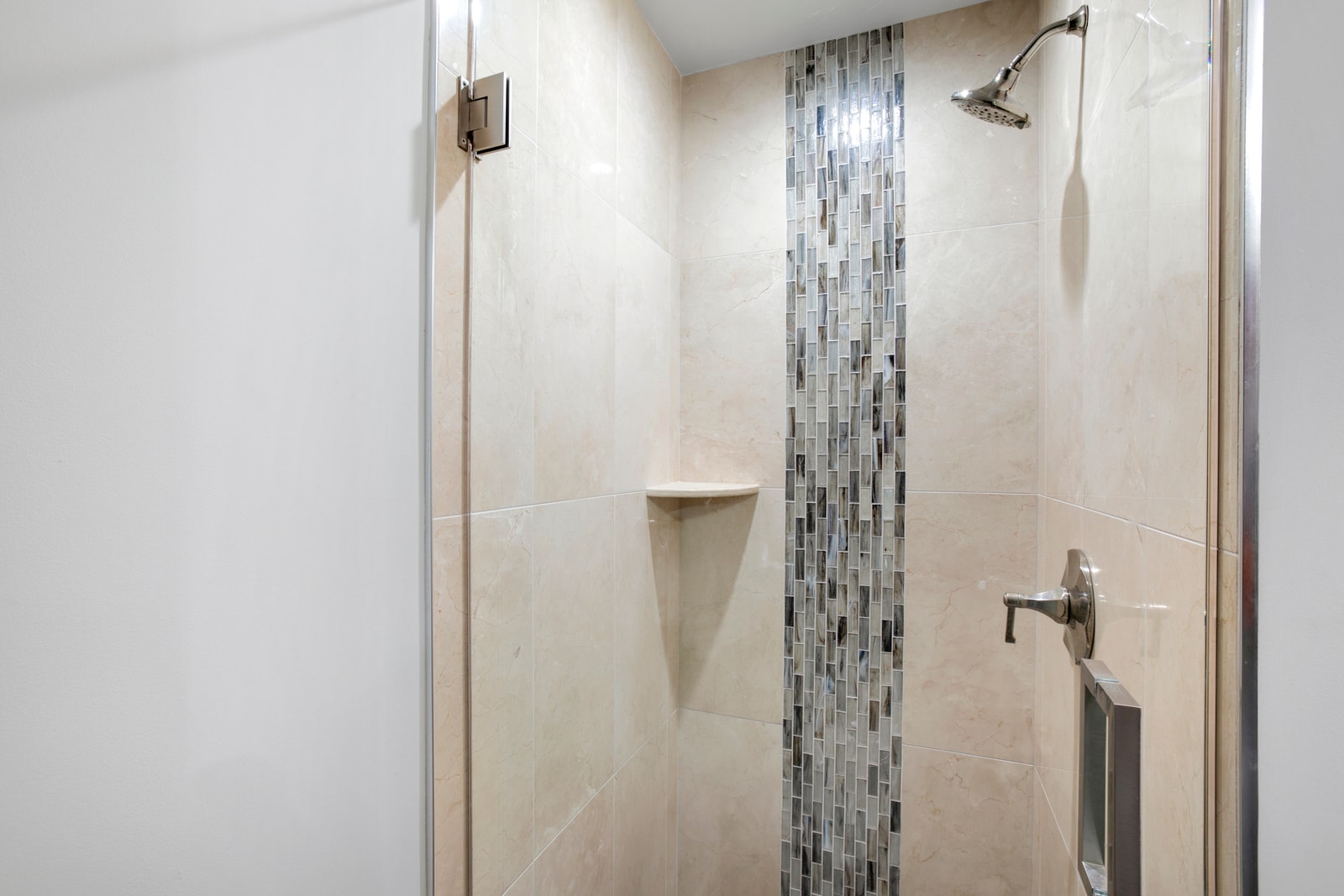 Let the waterfall mosaic tiles guide your eyes from head to toe in this serene shower that’s part spa, part sanctuary