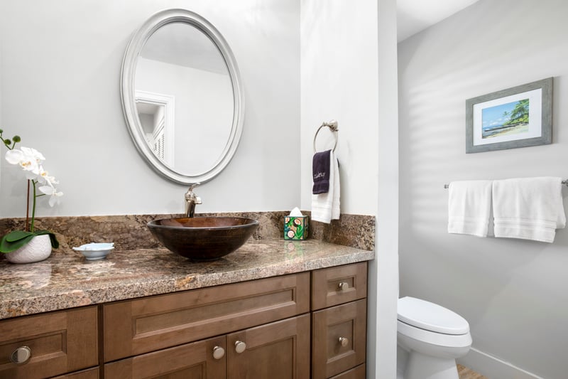 A vessel sink carved like nature’s own bowl rests atop granite counters, offering guests a refreshingly earthy elegance