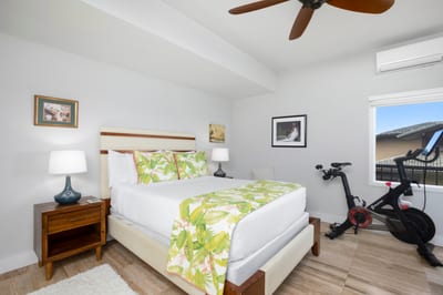 Luxury bedroom oasis with tropical decor and in-room Peloton bike.