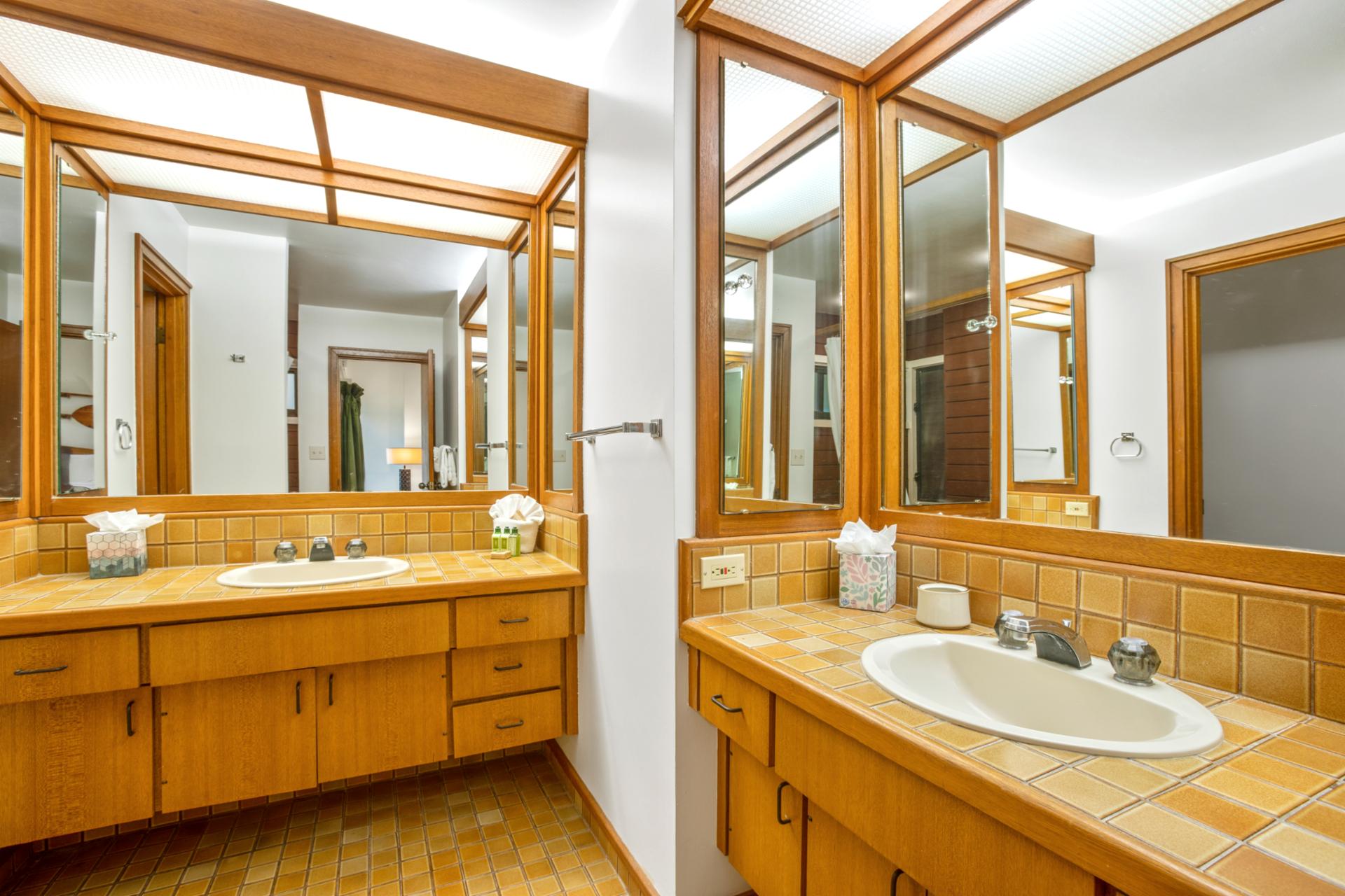 A refined bathroom space featuring dual vanities, where warm wood meets classic tile, creating a soothing blend of comfort and style