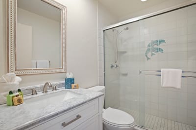Polished chrome fixtures and a marble-topped vanity blend timeless elegance with breezy comfort in this coastal retreat