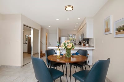 Dine beside ocean blues in this airy nook where sleek chairs, fresh florals, and seaside sunshine set the tone
