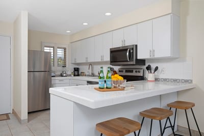 Whitewashed wonder with stainless sparkle—this kitchen is crisp, coastal, and perfect for sunset-seasoned bites