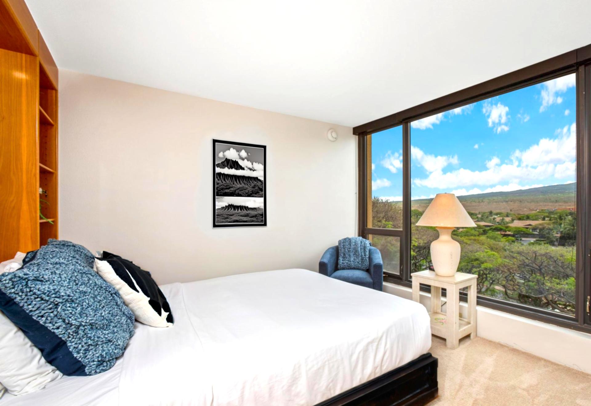 Bright and comfortable guest bedroom featuring a queen bed and wide, spacious windows