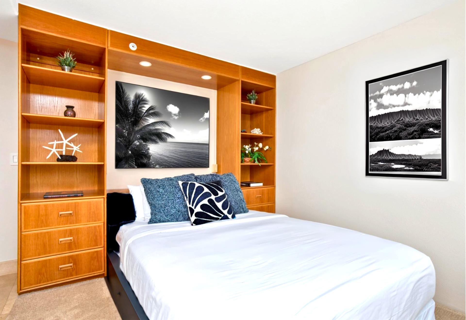 A cozy retreat featuring a queen bed for extra guests with thoughtful touches and island artwork