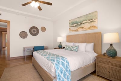 The king-size bed, adorned with cool aqua accents, offers an indulgent escape after sunlit island adventures MON-6301