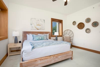 Sunlight pours through picture windows, casting a warm glow across soft linens and gentle ocean-toned accents MON-6301