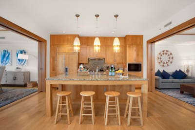 Pendant lights dangle like cheerful lemon drops above a kitchen where joy is clearly part of the recipe MON-6301