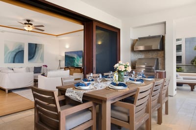 Gather around this beautifully set table, where golden light spills in and the ocean horizon winks beyond the palms MON-6301