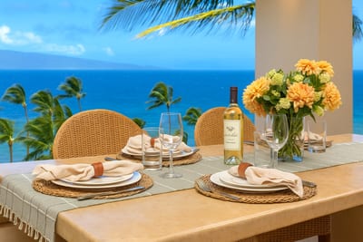 Gather beneath the shade of elegance—rattan chairs, fresh florals, and the Pacific shimmering just beyond your plate