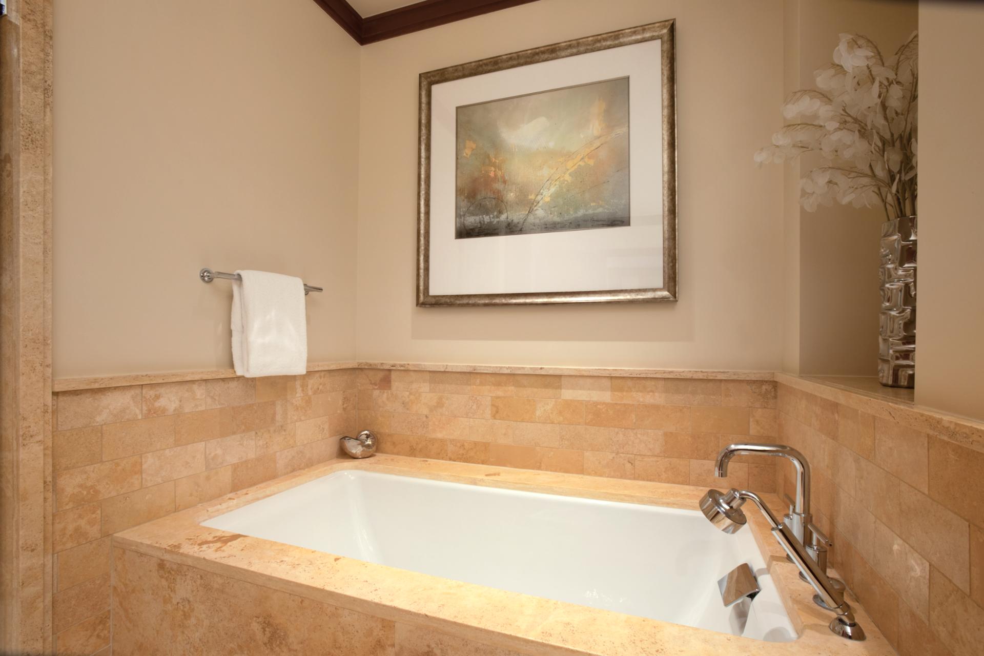 A soaking tub set beneath soft lighting makes this guest bath a serene escape