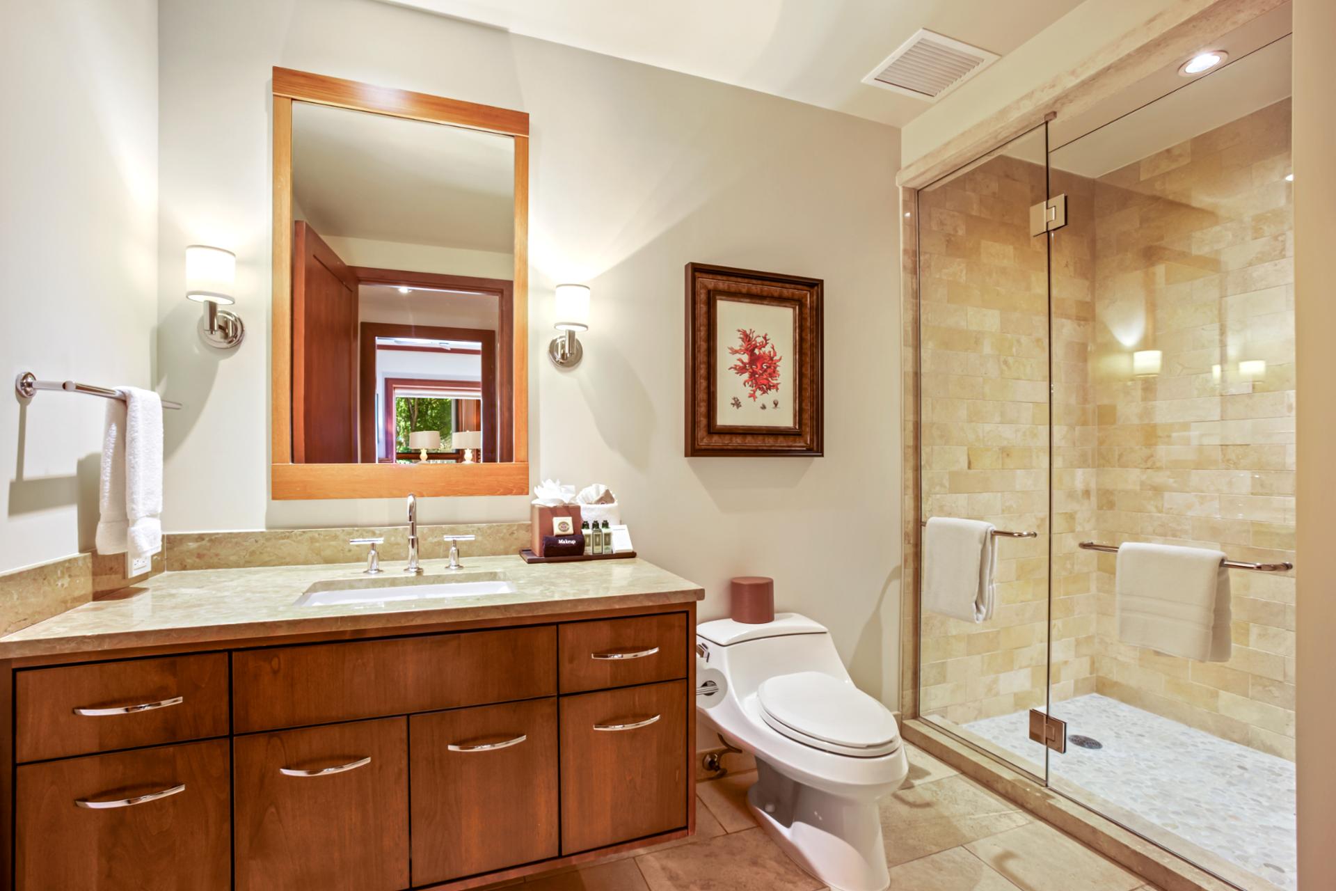 Clean and elegant, this bathroom includes a large glass walk in shower and soft lighting