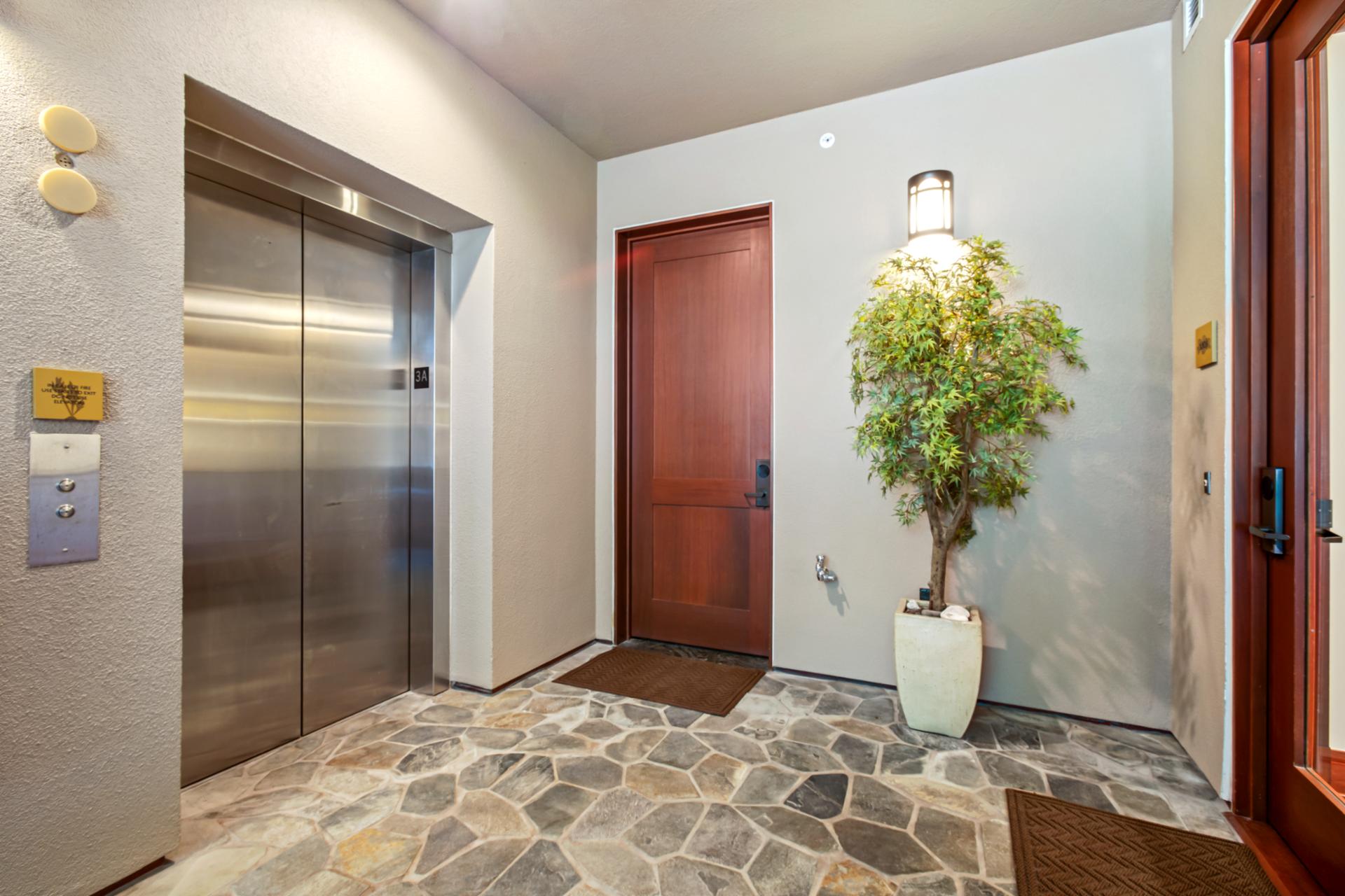 A spacious entry framed by island stonework and an elevator welcomes you to paradise