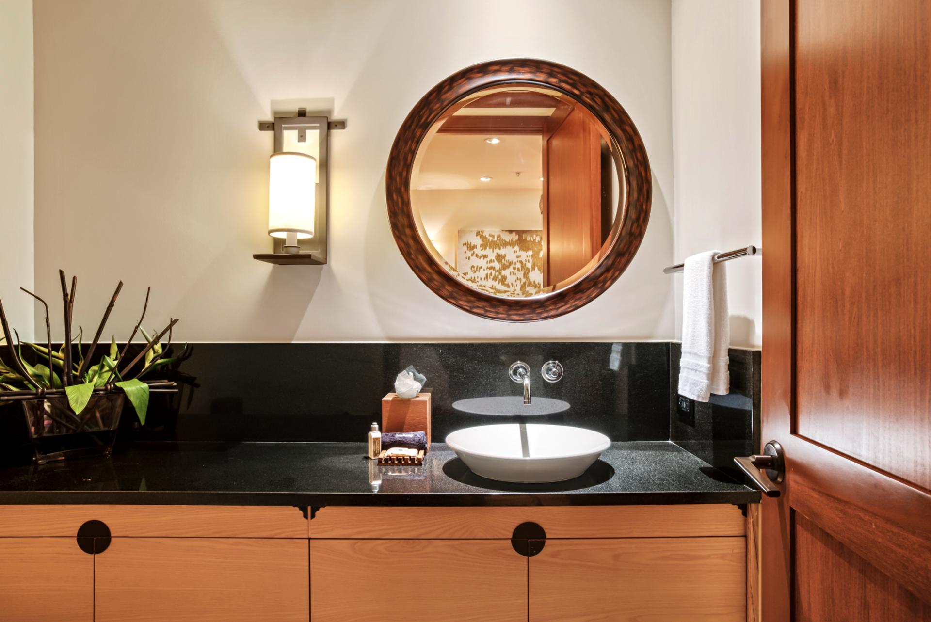 Unique accents and a stylish round mirror give this guest bathroom a designer feel