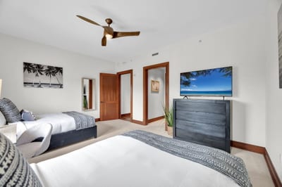 Bright and airy guest room with twin beds and coastal views
