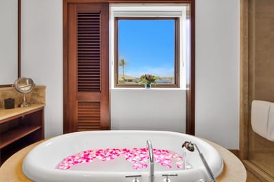 Setup your romantic bath with rose petals and natural light for a serene escape