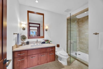 Stylish guest bath with granite vanity and glass walk-in shower