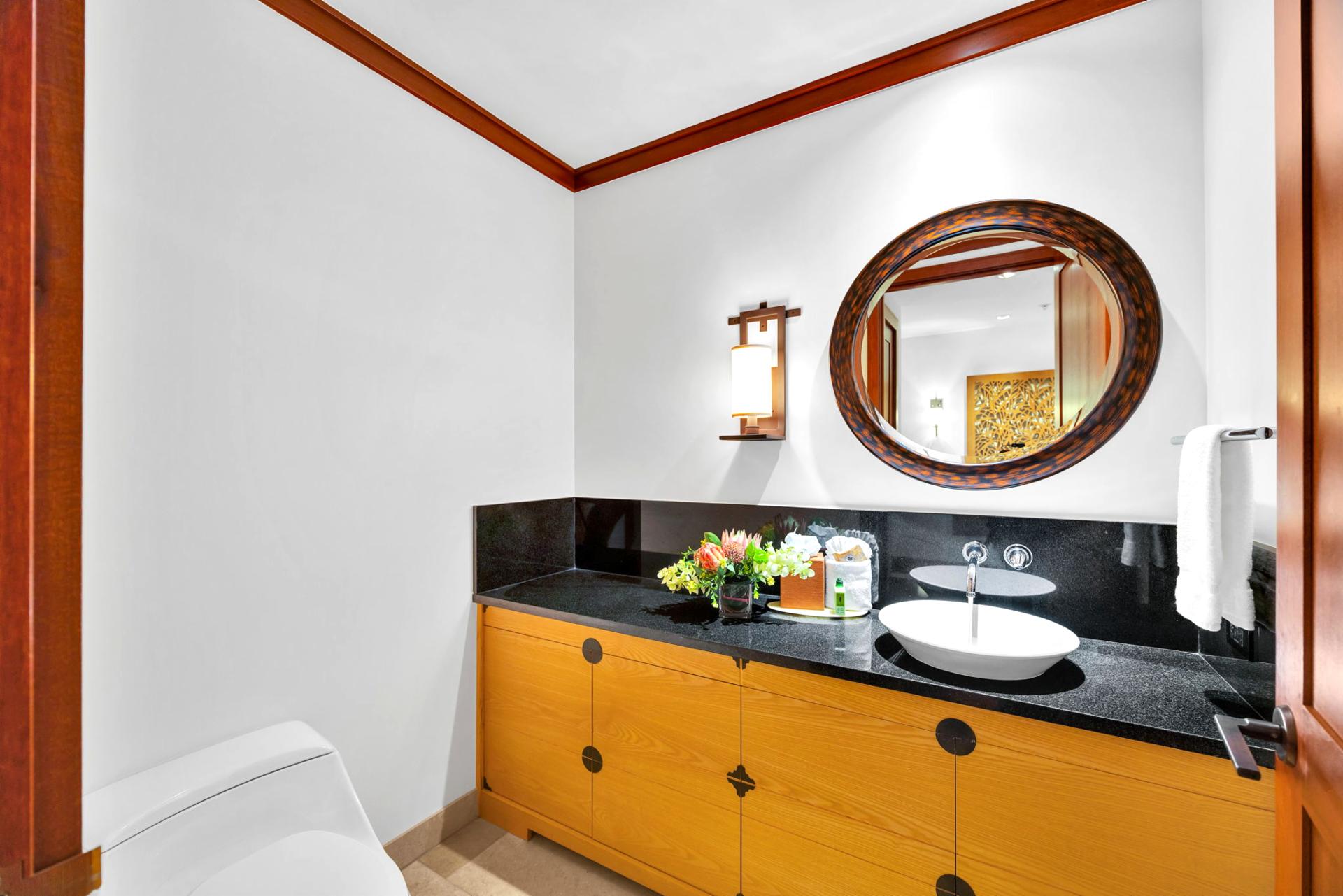 The hall bath features an elegant black marble countertop and is perfect for touching up before heading out to dinner